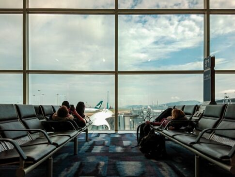 空港のベンチで飛行機を待つ旅行者