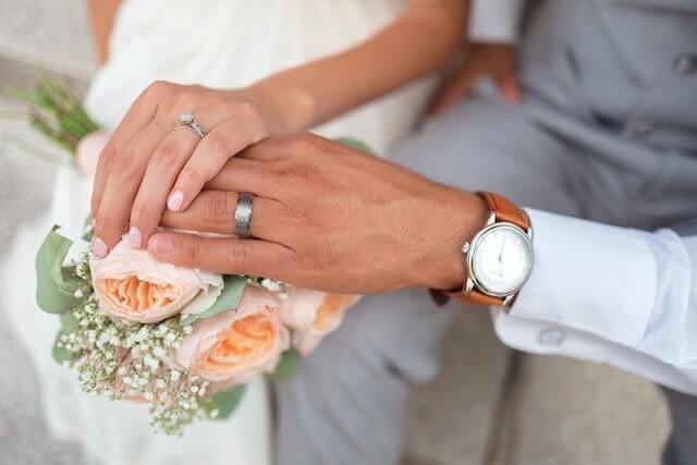 結婚指輪をして手を繋ぎ合う夫婦