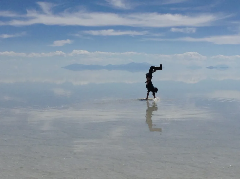 ウユニ塩湖で逆立ちする旅行者